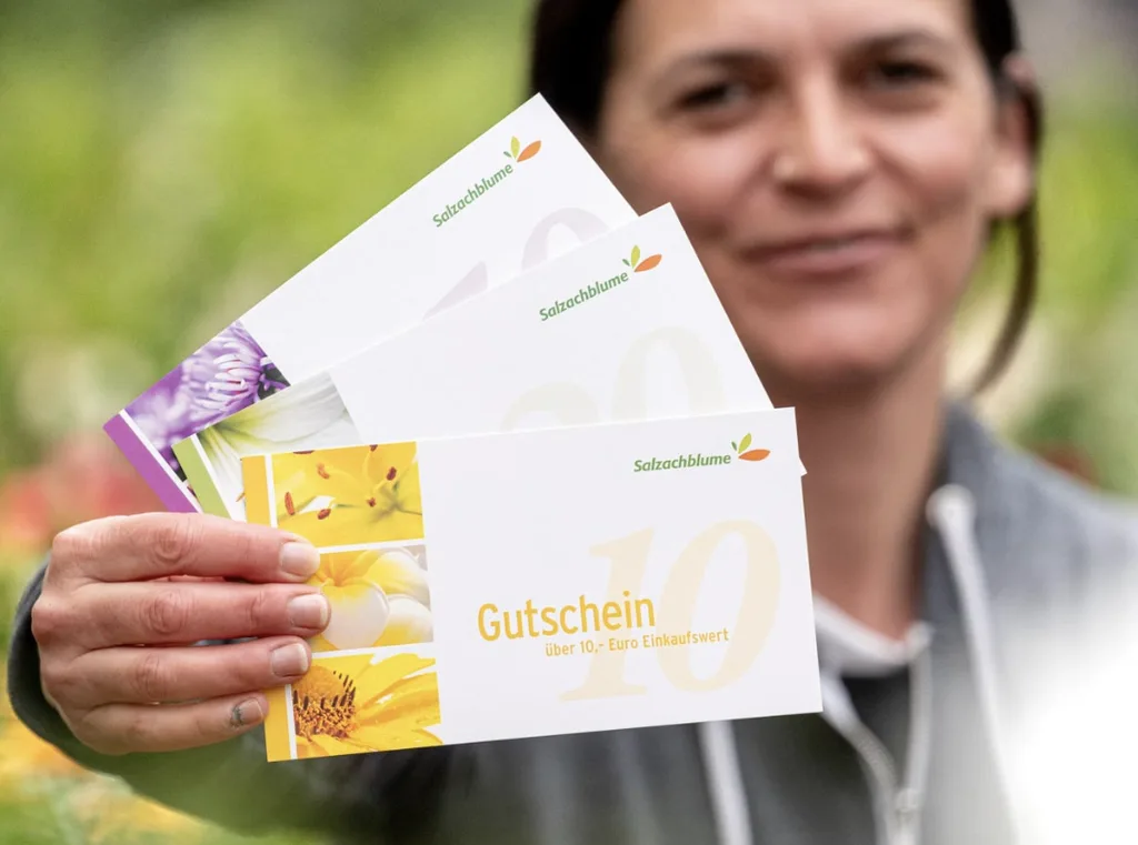 Kundin haelt mehrere Salzachblume-Gutscheine in der Hand